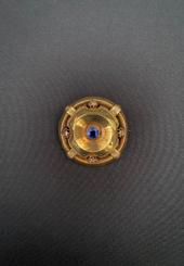 Broche « bouclier » en or jaune 18k ajourée ornée d’une pierre fine bleue